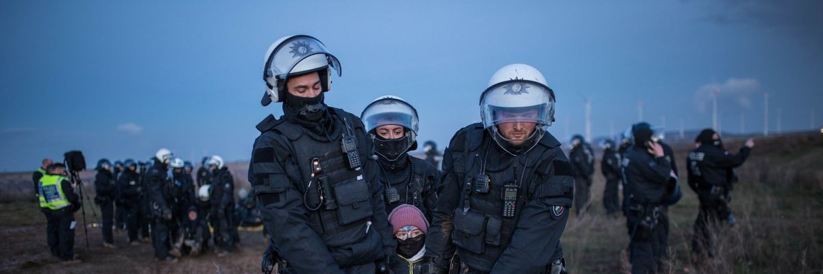 Police officers detain a climate activist at a demonstration against the expansion of the Garzweiler coal mine near the village of Luetzerath