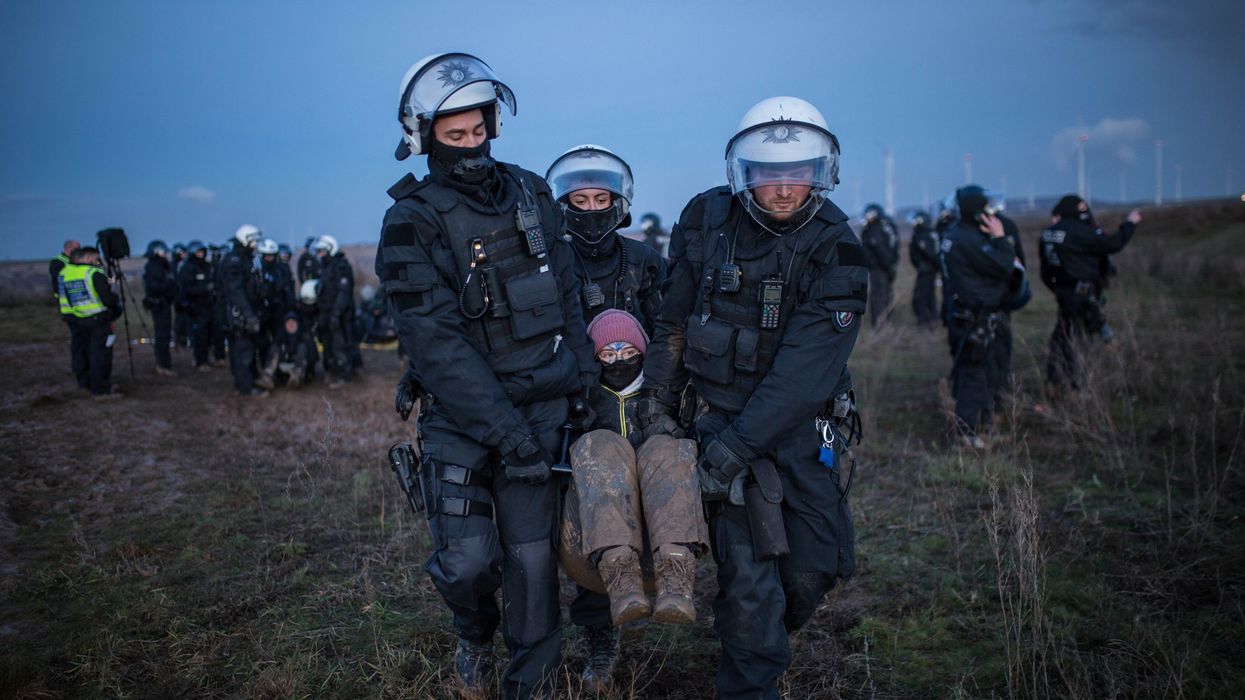 Police officers detain a climate activist at a demonstration against the expansion of the Garzweiler coal mine near the village of Luetzerath