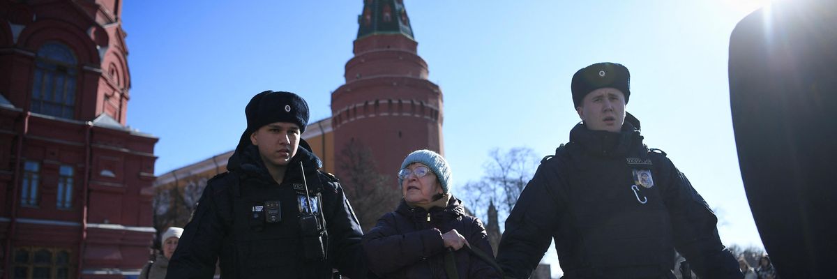 Police officers detain an elderly woman as she protests against Russia's invasion of Ukraine, in central Moscow on March 20, 2022.