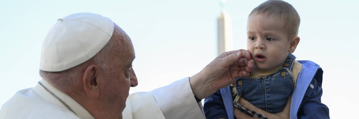 Pope Francis greets a child.