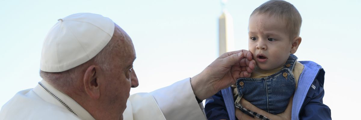Pope Francis greets a child.
