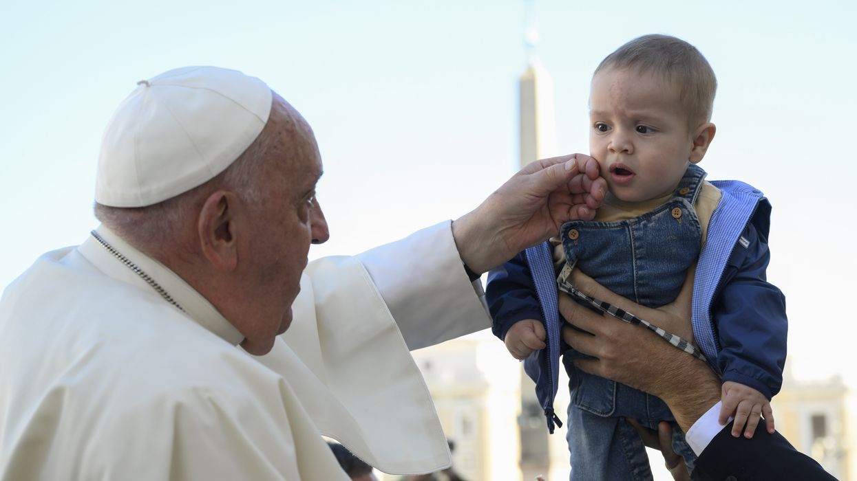 Pope Francis greets a child.