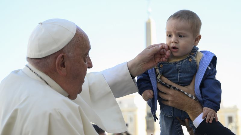 Pope Francis greets a child.