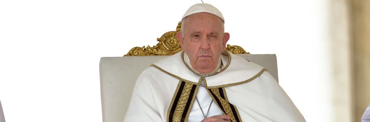 Pope Francis sits in a chair.