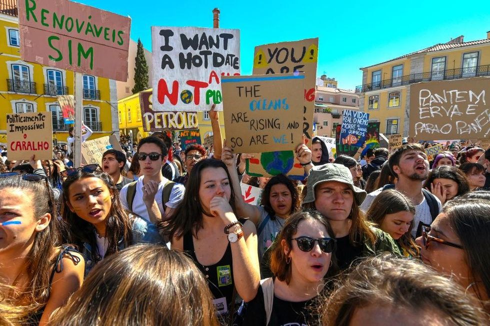 Portuguese students chant and hoist placards in front of the Assembleia da Republica (Portuguese Parliament) during their demonstration to support actions for climate change on March 15, 2019 in Lisbon, Portugal. Thousands of Portuguese students from universities and schools across the country join the international 'SchoolStrike4Climate' global protest, skipping classes and marching in protest against climate change. (Photo by Horacio Villalobos#Corbis/Getty Images)