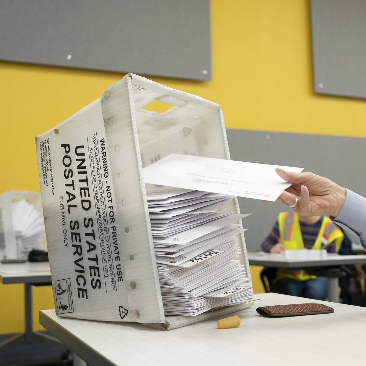 postal workers sort mailed ballots