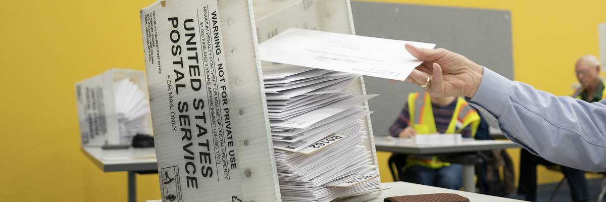 postal workers sort mailed ballots