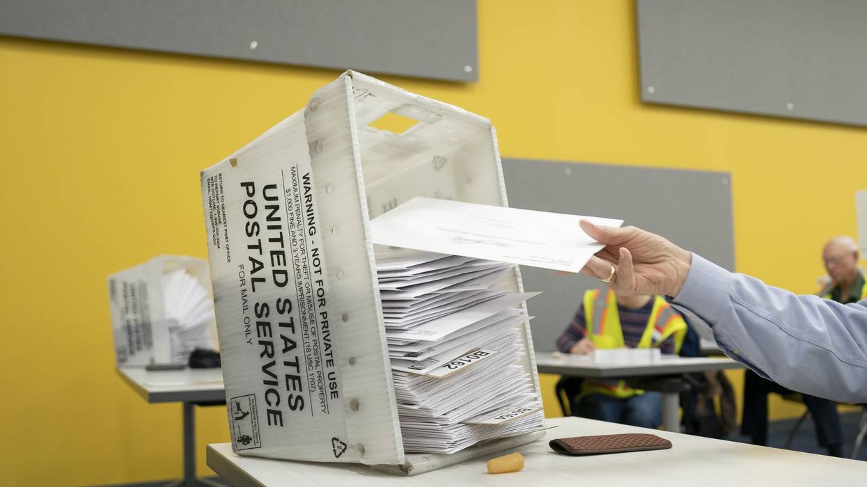 postal workers sort mailed ballots