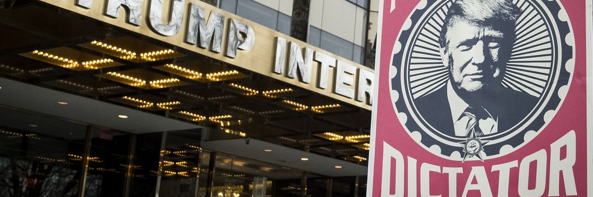 Poster of Trump saying "Not my dictator" held in front of Trump tower.