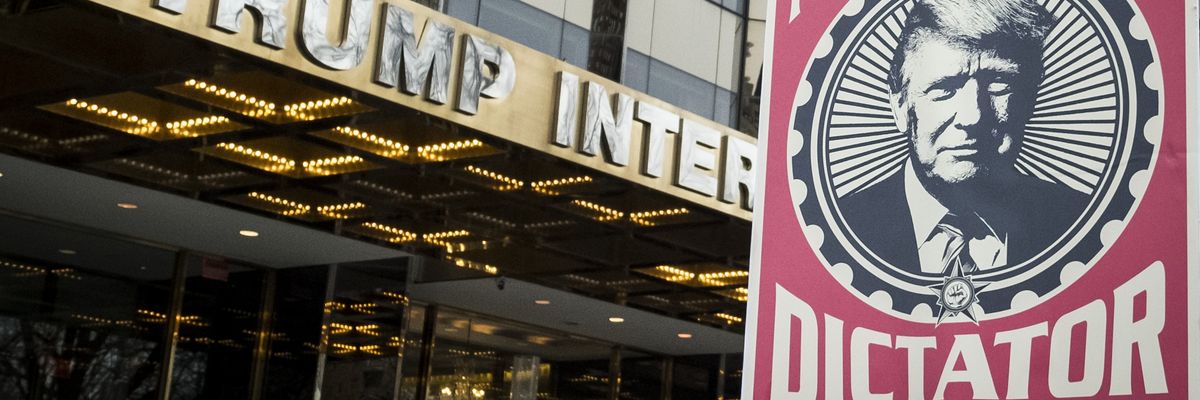 Poster of Trump saying "Not my dictator" held in front of Trump tower.