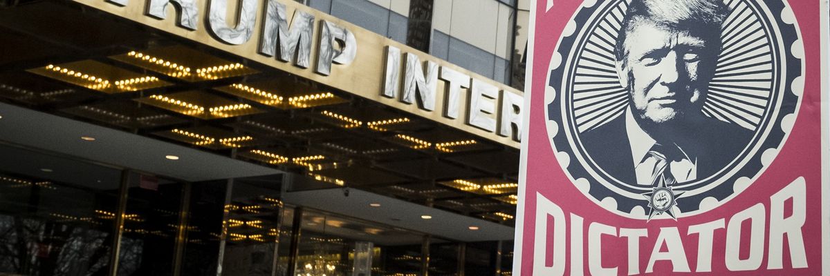 Poster of Trump saying "Not my dictator" held in front of Trump tower.