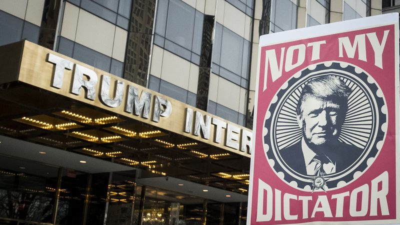 Poster of Trump saying "Not my dictator" held in front of Trump tower.