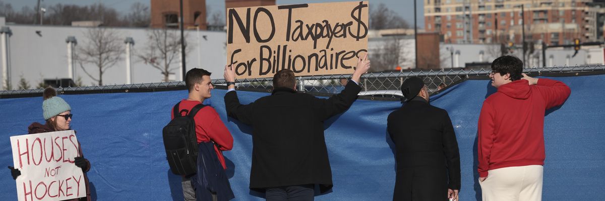 Potomac Yard development protesters hold signs against barrier.