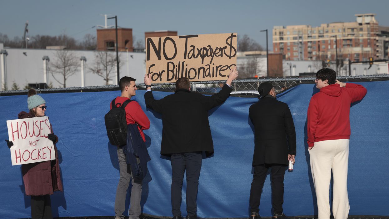 Potomac Yard development protesters hold signs against barrier.