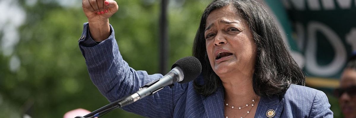 Pramila Jayapal speaks with a raised fist