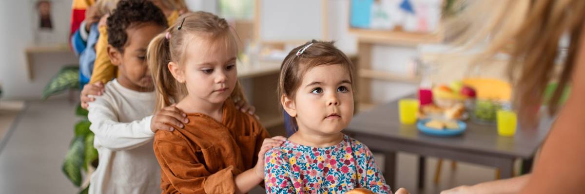 Pre-school children lining up for food.