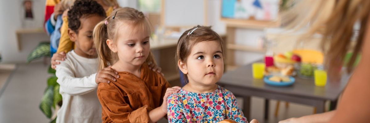 Pre-school children lining up for food.