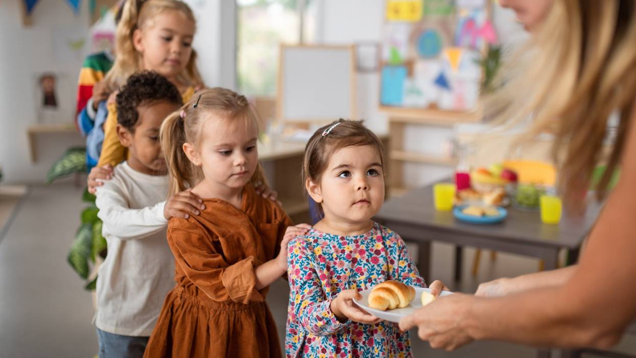 Pre-school children lining up for food.