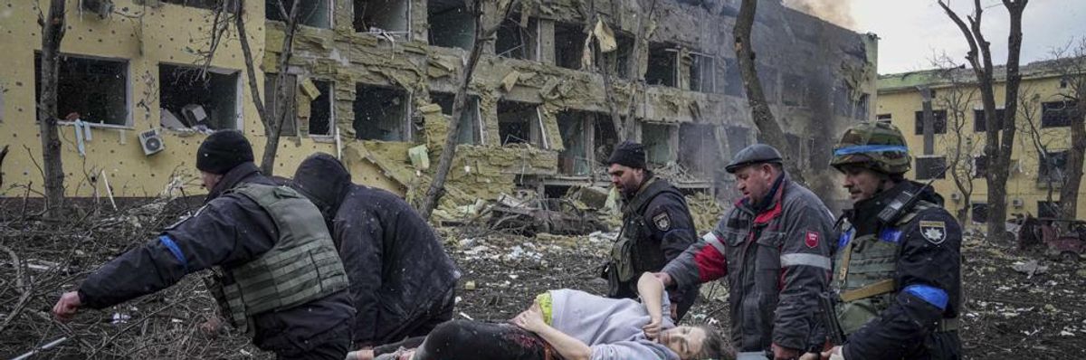 Pregnany mother and baby being carried on stretcher by soldiers after hospital bombing