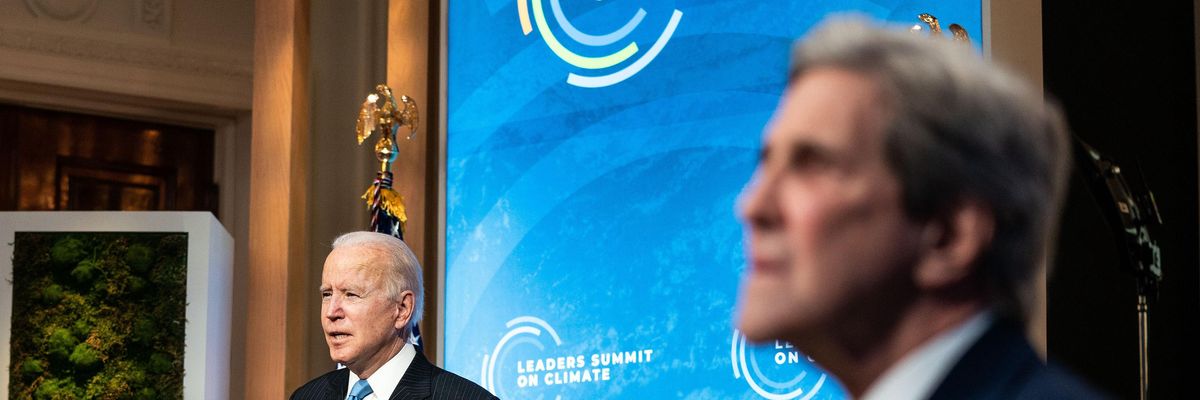 President Biden speaks as climate envoy John Kerry listens