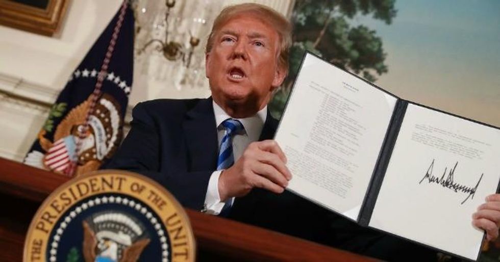 President Donald Trump holds up a memorandum that re-instates sanctions on Iran after he announced his decision to withdraw the United States from the 2015 Iran nuclear deal in the Diplomatic Room at the White House May 8, 2018 in Washington, D.C. (Photo: Chip Somodevilla/Getty Images)