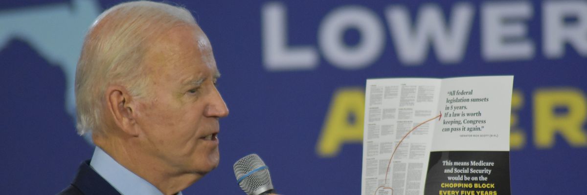 President Joe Biden holds up a pamphlet spotlighting the GOP's attacks on Social Security