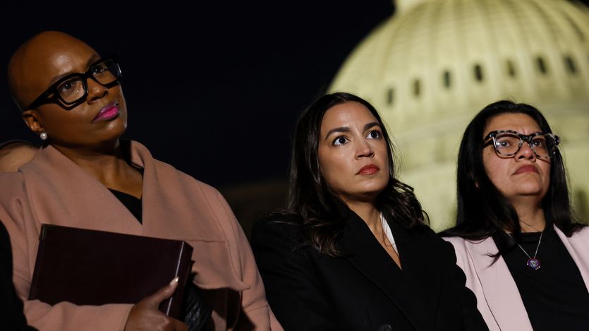 Pressley, Ocasio-Cortez, and Tlaib listen outside U.S. Capitol building at night.