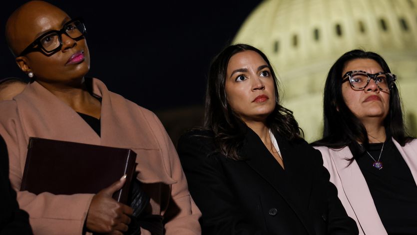 Pressley, Ocasio-Cortez, and Tlaib listen outside U.S. Capitol building at night.