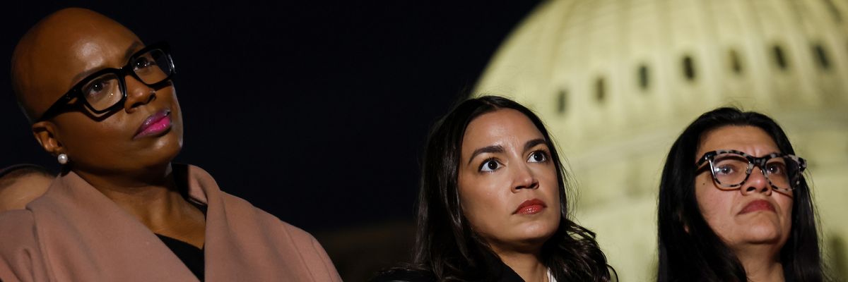 Pressley, Ocasio-Cortez, and Tlaib listen outside U.S. Capitol building at night.