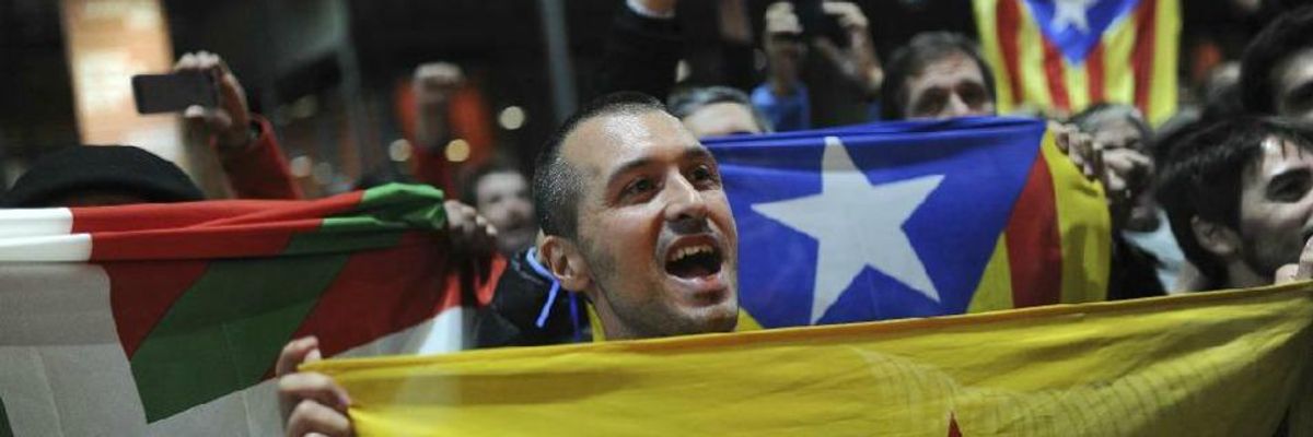 Pro-independence supporters hold a Catalan flag during a meeting organized by the Catalonia National Assembly at a polling station in Barcelona on November 9, 2014.