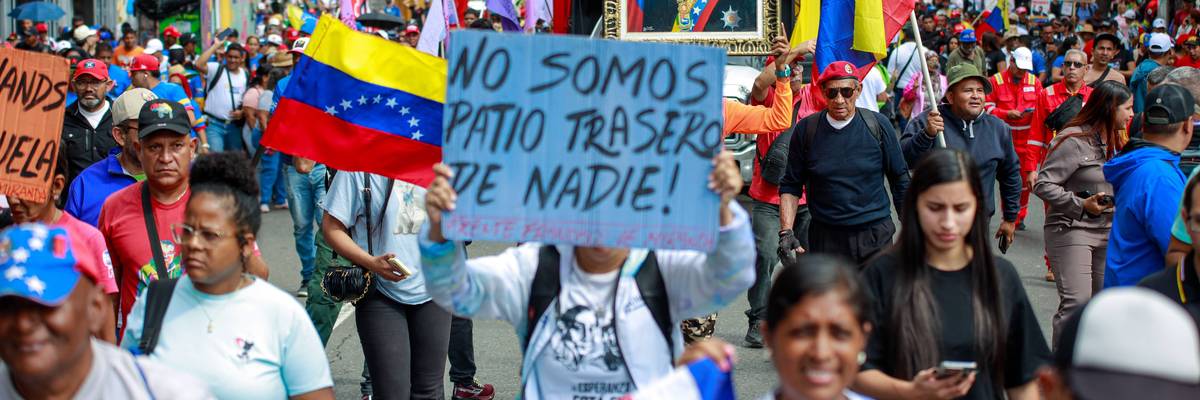 Pro-Maduro supporters march in Caracas; one holds a sign saying, "We are nobody's backyard."