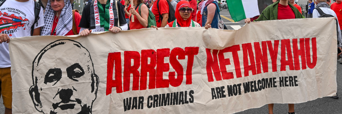 Pro-Palestine protesters hold a banner reading, "Arrest Netanyahu: War Criminals Are Not Welcome Here"