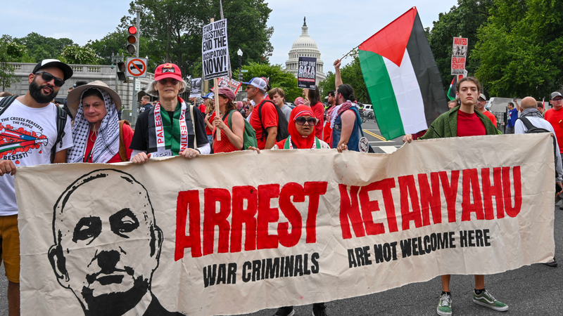 Pro-Palestine protesters hold a banner reading, "Arrest Netanyahu: War Criminals Are Not Welcome Here"