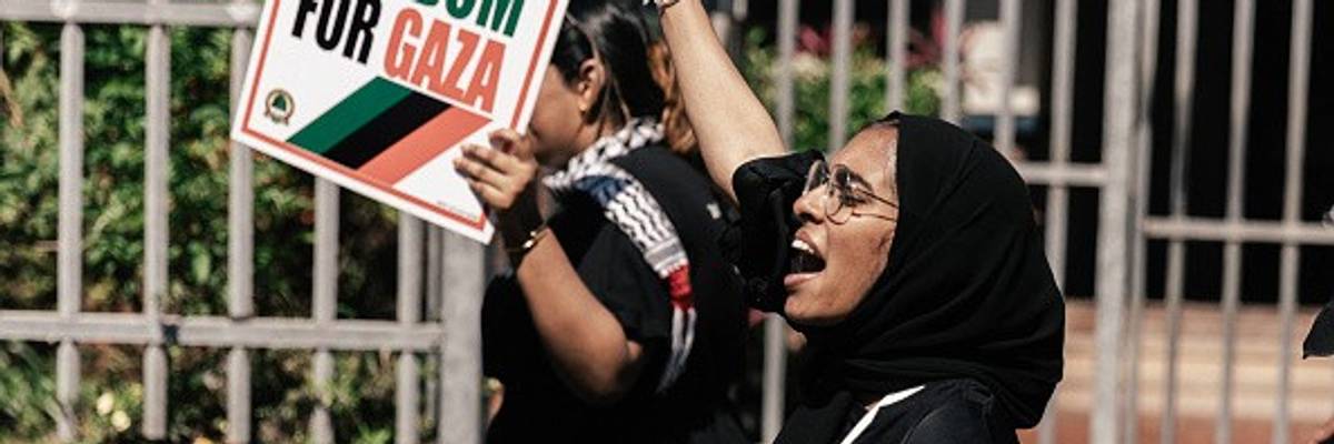 Pro-Palestinian activists hold placards and shout slogans