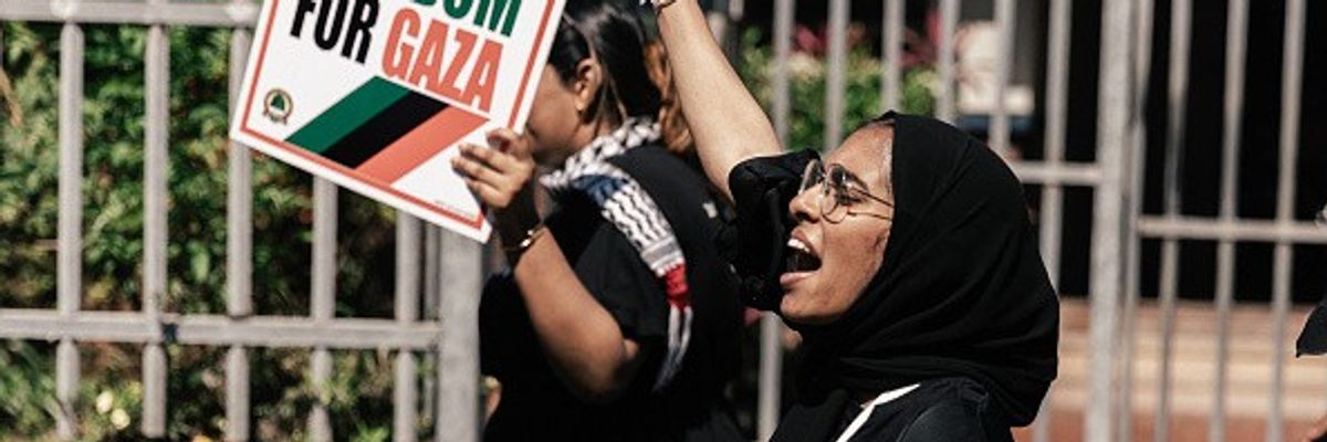Pro-Palestinian activists hold placards and shout slogans