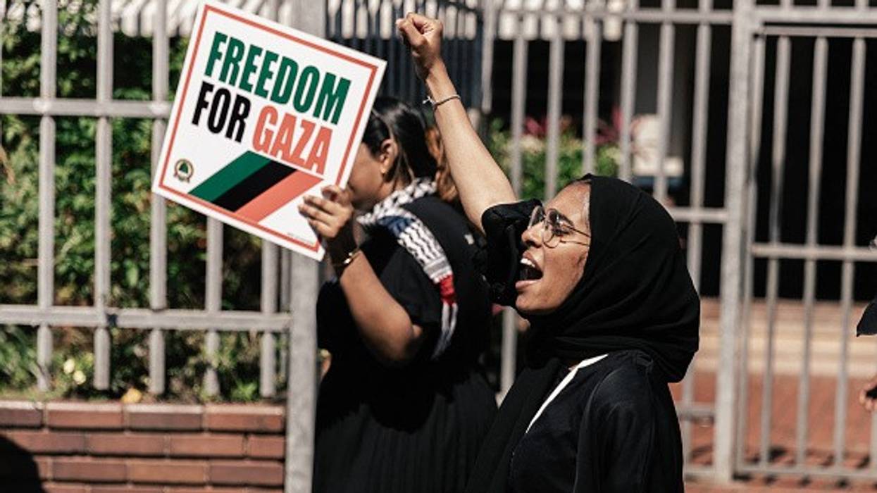 Pro-Palestinian activists hold placards and shout slogans