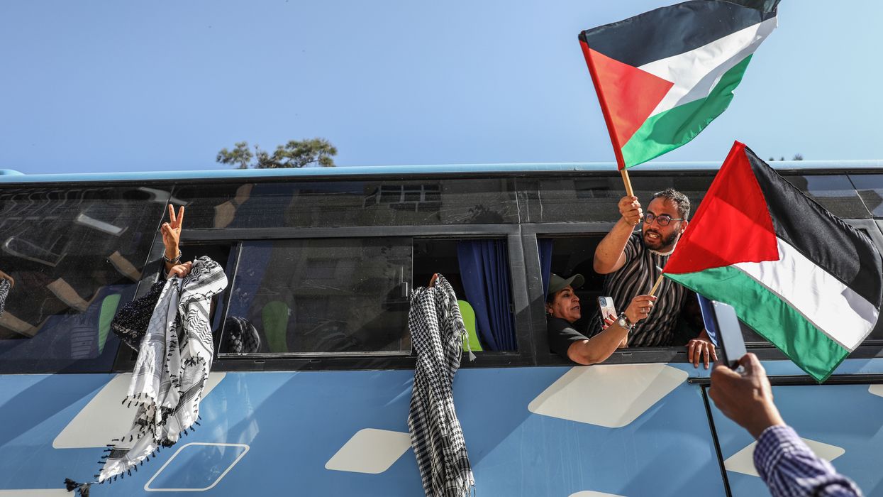 Pro-Palestinian activists wave Palestinian flags and keffiyehs from open bus windows
