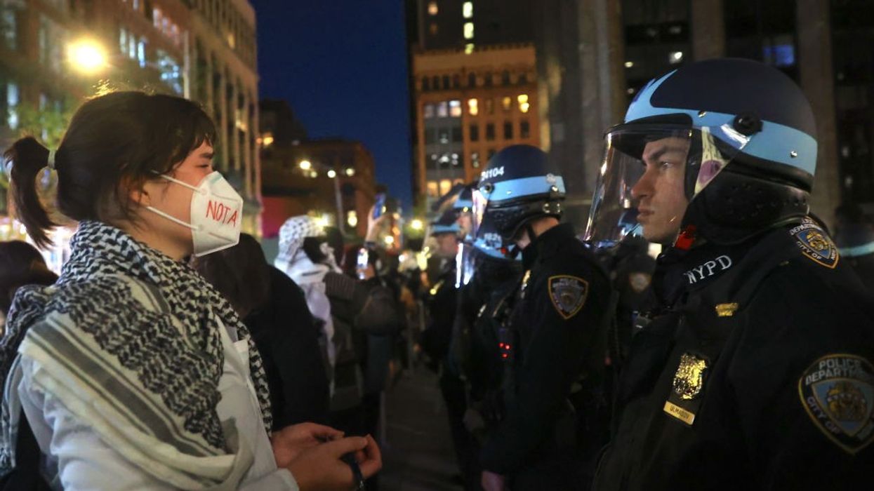 Pro-Palestinian protester faces NYPD officers near New York University