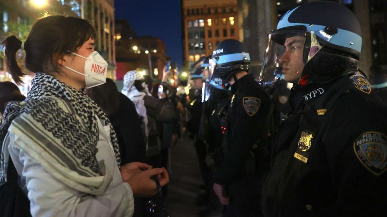 Pro-Palestinian protester faces NYPD officers near New York University