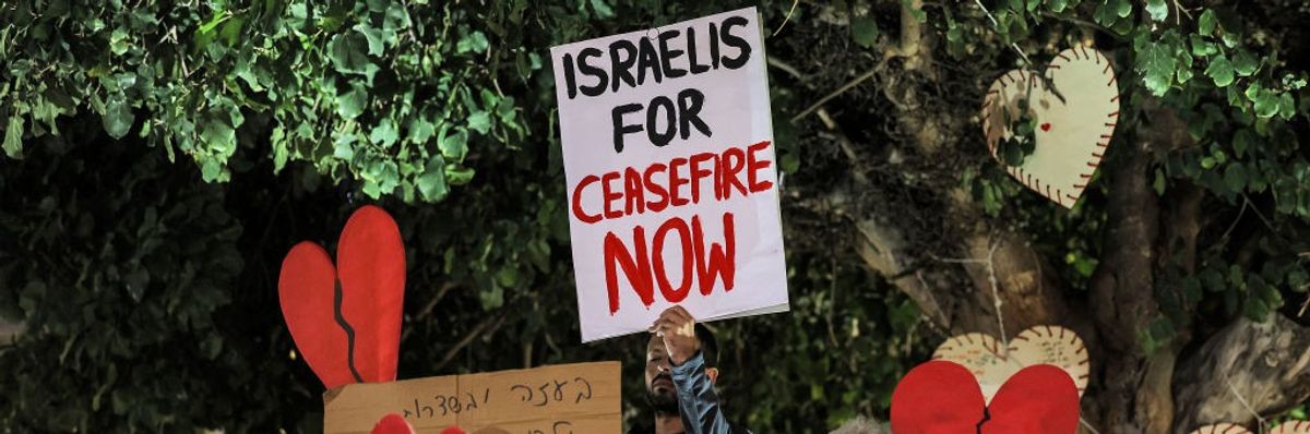 Pro-peace demonstrators gather in Tel Aviv ather with broken heart signs and placard that says "Isreali for Ceasefire Now"