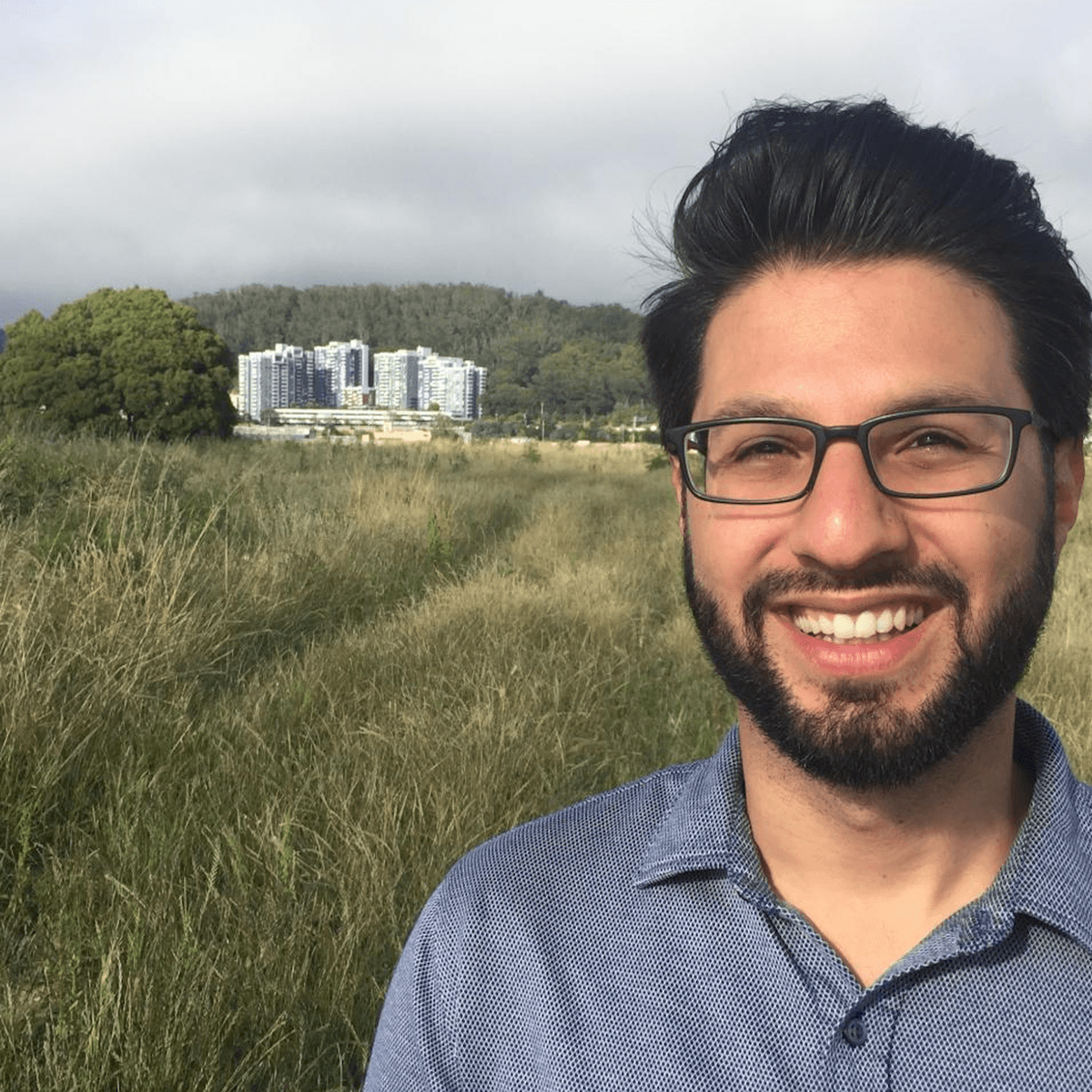 Professor Aria Fani stands in a field