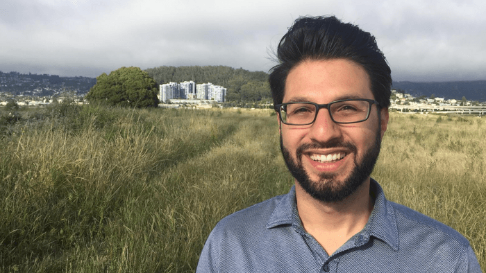 Professor Aria Fani stands in a field 