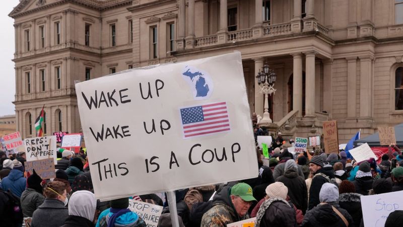 Protest against Trump with sign saying, "Wake up, wake up, this is a coup."