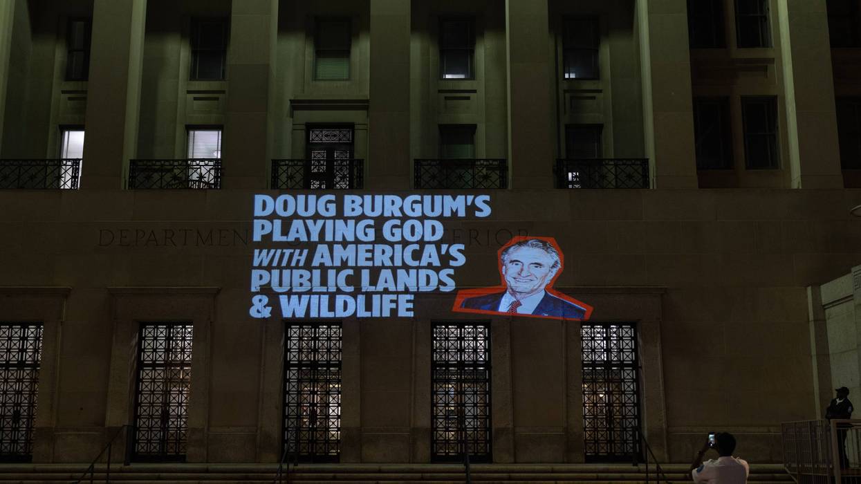 Protest messages are projected at the US Department of the Interior