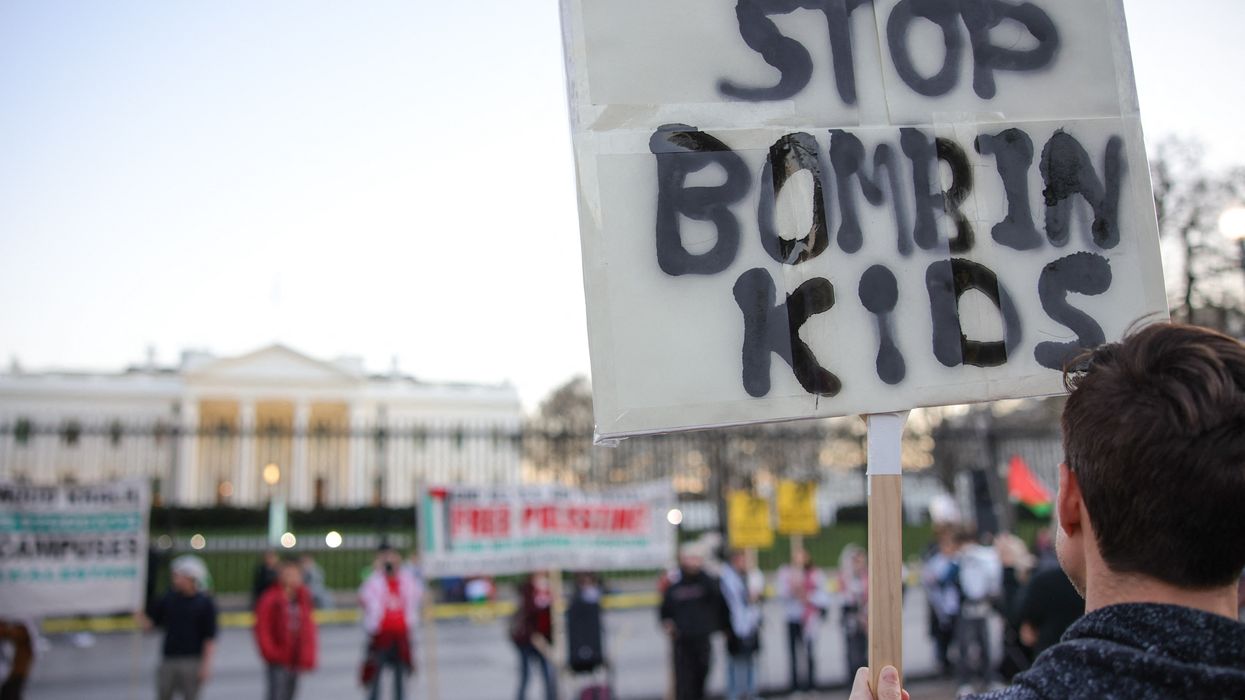 Protest sign in front of White House reads, "Stop bombing kids."