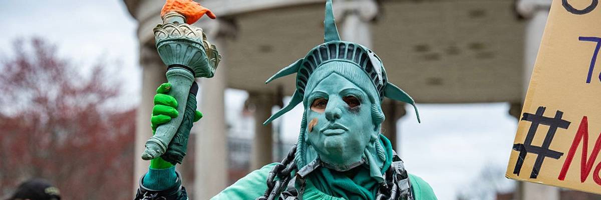 Protester as statue of liberty in chains.