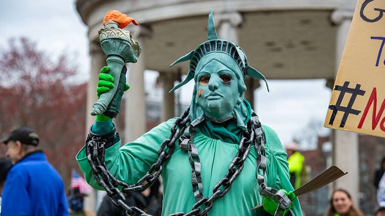 Protester as statue of liberty in chains.
