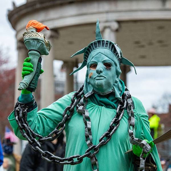 Protester as statue of liberty in chains.