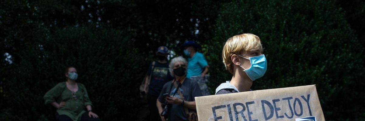Protester holds 'Fire DeJoy, save our USPS' sign