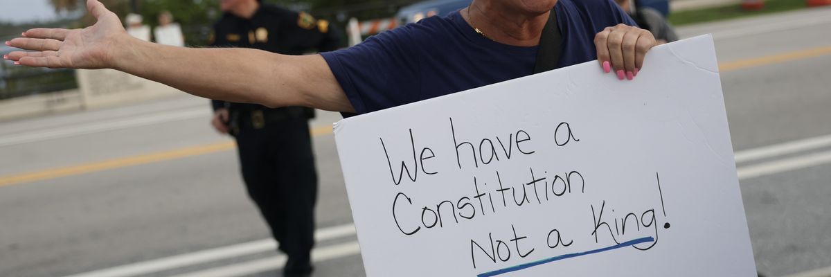 Protester holds sign reading, "We have a Constitution, not a king!"